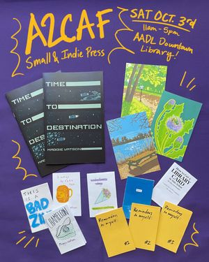 Image of comics, prints and zines laid out on a tablecloth along with info about the event.