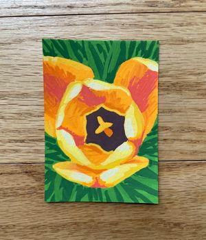 A small marker drawing of an open tulip, looking into the center of the flower. The edges of the petals are bright yellow, with warm orange and red in the centers. The background is green and textured like grass.