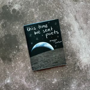 Zine titled 'this time we sent poets' by Maggie Watson lying on a backdrop image of the moon. The cover features the 'Earthset' image from artemis ii of a crescent earth behind the edge of the moon.